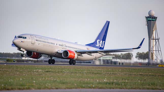 SAS Scandinavian Airlines Boeing 737-800 aircraft as seen during taxiing, rotation, take off and fly phase while departing from Amsterdam Schiphol AMS EHAM.