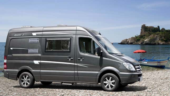 A grey Mercedes Sprinter parked by a lake 