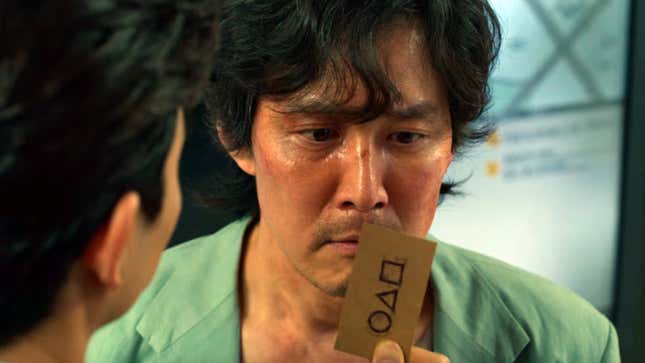 Lee Jung-jae as Seong Gi-hun looks at the business card from Squid Game.