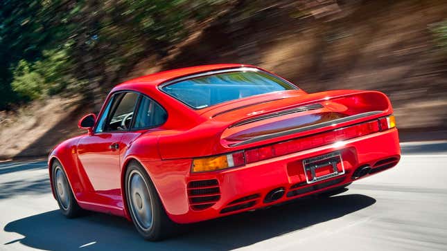 A photo of the rear quarter of a red Porsche 959 supercar. 