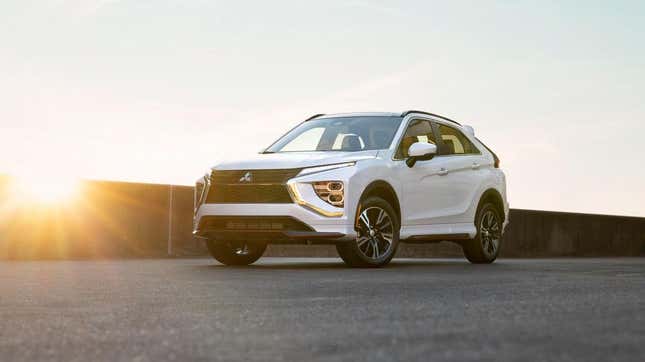 A white Eclipse Cross parked in front of a wall at sunset