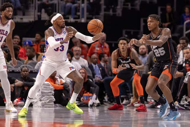 Nov 10, 2023; Detroit, Michigan, USA; Detroit Pistons guard Marcus Sasser (25) passes the ball past Philadelphia 76ers forward Robert Covington (33) during the in the first half at Little Caesars Arena.