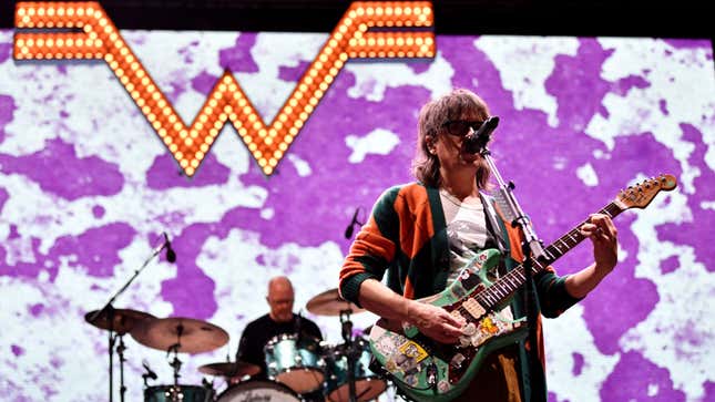 A photo of the band Weezer performing live. 