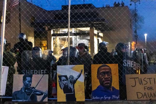 Elijah McClain and George Floyd pictures left by demonstrators line up the fence outside the Brooklyn Center police station while protesting the death of Daunte Wright who was shot and killed by a police officer in Brooklyn Center, Minnesota on April 14, 2021. - Minneapolis has been roiled by nights of violent protests after police officer Kim Potter, who is white, opened fire on Black 20-year-old Daunte Wrigh in his car on April 11. Potter, who shot dead Daunte Wright in a Minneapolis suburb after appearing to mistake her gun for her Taser, was arrested on April 14 and will face manslaughter charges. 