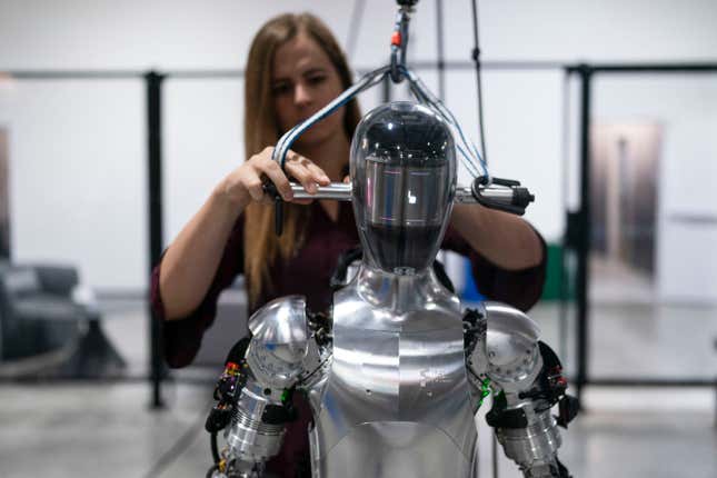 FILE - AI engineer Jenna Reher works on humanoid robot Figure 01 at Figure AI&#39;s test facility in Sunnyvale, Calif., Oct. 3, 2023. ChatGPT-maker OpenAI is looking to fuse its artificial intelligence systems into the bodies of humanoid robots as part of a new deal with robotics startup Figure. Sunnyvale, California-based Figure announced the partnership Thursday, Feb. 29, 2024, along with $675 million in venture capital funding from a group that includes Amazon founder Jeff Bezos as well as Microsoft, chipmaker Nvidia and the startup-funding divisions of Amazon, Intel and OpenAI. (AP Photo/Jae C. Hong, File)