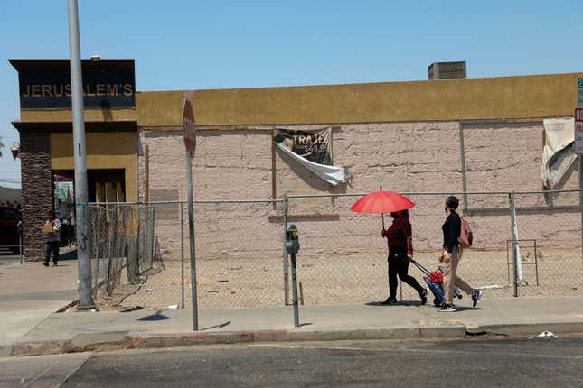 People walk downtown as the temperature reached around 115 degrees in early June in Calexico, California.