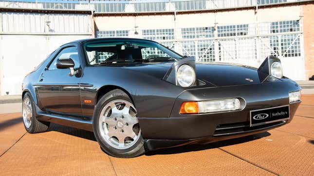 Front 3/4 view of a grey 1989 Porsche 928 GT Flachbau with the headlights popped up