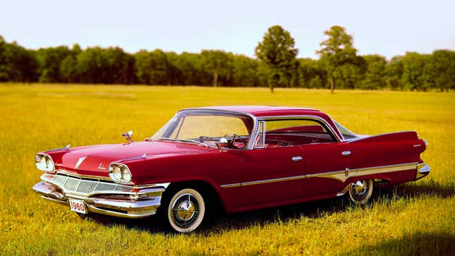 A red Dodge Dart parked in a field. 