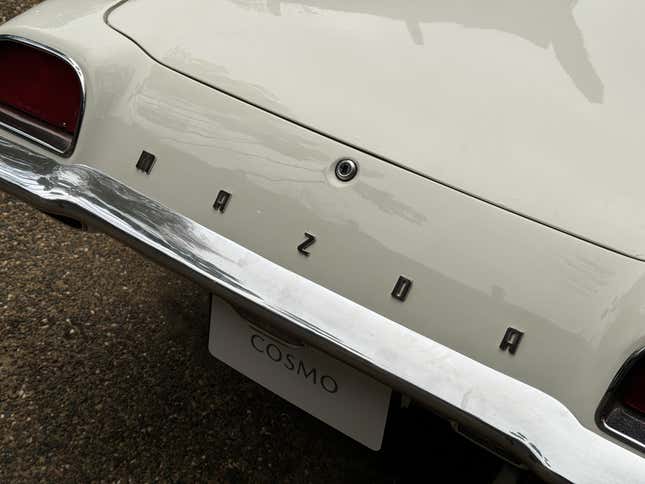 Detail photo of the rear badge of a white Mazda Cosmo 110S
