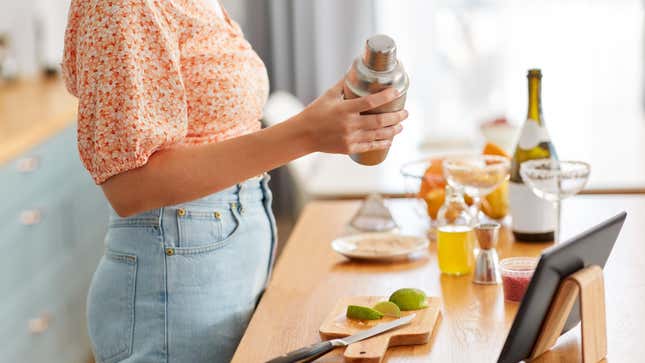 person making cocktail at home in kitchen