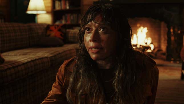 Charlie covered in mud and blood in a wooden cabin.