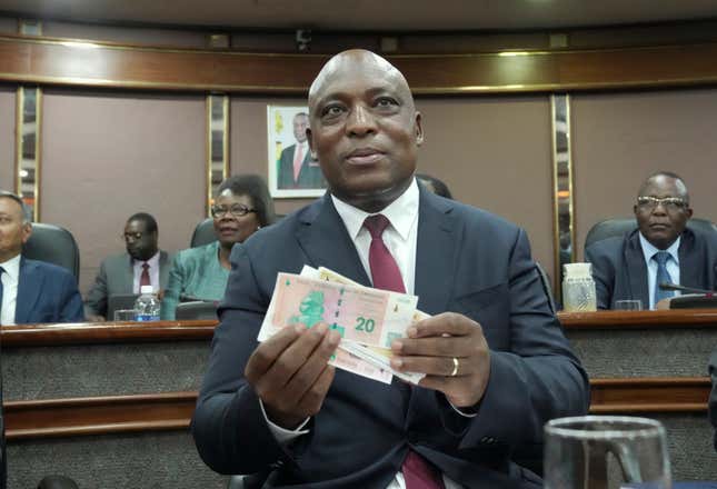 Reserve Bank of Zimbabwe Governor, John Mushayavanhu holds a sample of the country&#39;s new currency at a press briefing in Harare, Friday, April 5, 2024. Zimbabwe on Friday launched a new currency to replace a local unit that in recent months has been battered by depreciation, and in some instances rejected by the population, and authorities hope the new measure will arrest the currency crisis underlining the country&#39;s years long economic troubles. (AP Photo/Tsvangirayi Mukwazhi)