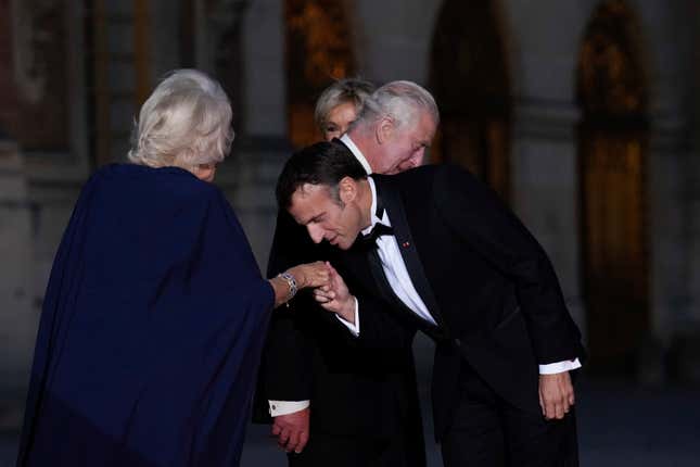 French President Emmanuel Macron kisses Britain&#39;s Queen Camilla hand as they arrive for a state dinner, at the Chateau de Versailles, west of Paris, Wednesday, Sept. 20, 2023. King Charles III of the United Kingdom starts a three-day state visit to France on Wednesday meant to highlight the friendship between the two nations with great pomp, after the trip was postponed in March amid widespread demonstrations against President Emmanuel Macron&#39;s pension changes. (AP Photo/Christophe Ena)