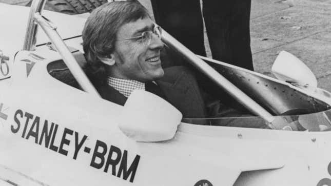 Larry Perkins sits in an old race car. 