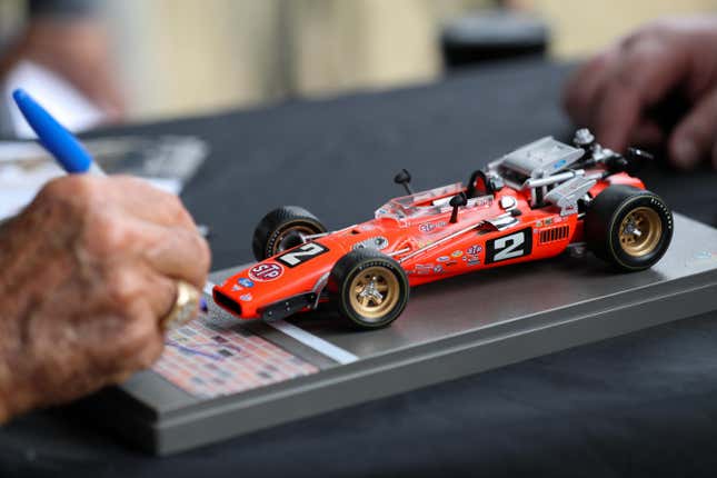 Mario Andretti signs a diecast of his 1969 Indy 500-winning car
