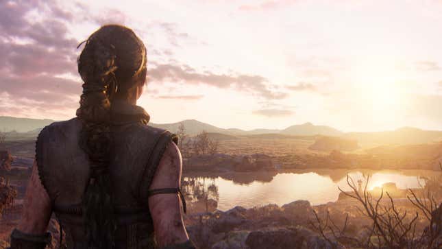 Senua looks out at a plain with mountains in the background.