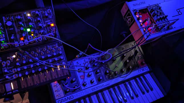 A photograph shows several modular synthesizers plugged into one another.