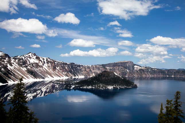 Clouds appear over Crater Lake on June 1, 2023, in Crater Lake, Ore. Management issues at Oregon&#39;s Crater Lake have prompted the federal government to consider terminating its contract with the national park&#39;s concessionaire. Crater Lake Hospitality is a subsidiary of Philadelphia-based Aramark and is contracted through 2030 to run concessions such as food and lodging. (AP Photo/Jenny Kane)