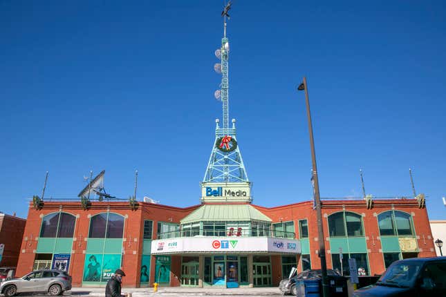 FILE - A person walks by the CTV Television Network studios in Ottawa, Quebec, Canada, on Monday, Feb. 14, 2022. Canada’s largest media and telecom company said Thursday, Feb. 8, 2024, it is ending multiple television newscasts and making other programming cuts after its parent company announced 4,800 layoffs and the sale of 45 of its 103 regional radio stations. (AP Photo/Ted Shaffrey, File)