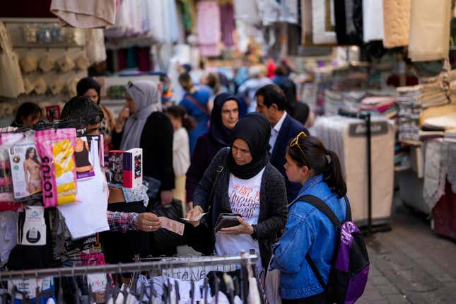 FILE - A seller attends a client in a street market at Eminonu commercial area in Istanbul, Turkey, on, June 7, 2023. Turkey’s central bank raised its key interest rate by 5 percentage points Thursday, another large but expected hike that signals a continued push toward more traditional economic policies under President Recep Tayyip Erdogan. (AP Photo/Francisco Seco, File)