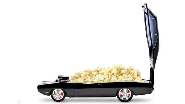 A dark sports car with its upper section tilted open to allow one to enjoy the delicious popcorn filling the interior.