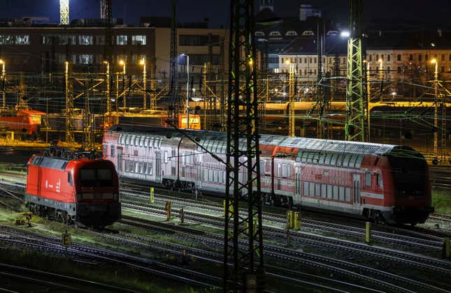 A suburban train and an electric locomotive stand on sidings at Leipzig Central Station in the early morning in Leipzig, Germany, Monday Dec. 18, 2023. Members of a union representing German train drivers have voted overwhelmingly to stage open-ended strikes in a bitter dispute with the main national railway operator over working hours and pay, union leaders said Tuesday, Dec. 19, 2023. (Jan Woitas/dpa via AP)