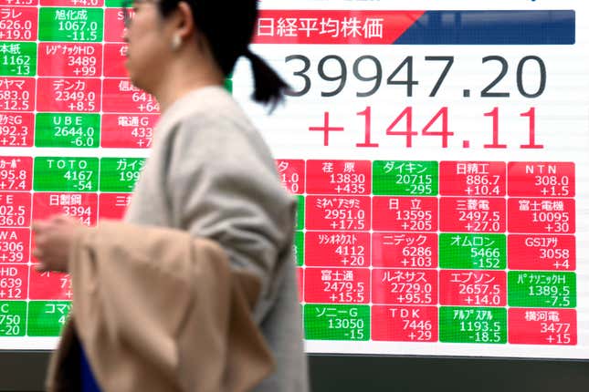 A person walks in front of an electronic stock board showing Japan&#39;s Nikkei 225 index at a securities firm Tuesday, April 2, 2024, in Tokyo. Asian shares were mixed on Tuesday after Wall Street pulled back from its record following a shaky day of trading, putting at least a temporary halt to its huge rally since Halloween. (AP Photo/Eugene Hoshiko)