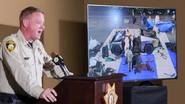 Un monitor muestra una imagen de las autoridades que investigan un camión cibernético Tesla que explotó el día de Año Nuevo frente a la entrada del Trump International Hotel & Tower Las Vegas mientras el sheriff del Departamento de Policía Metropolitana de Las Vegas, Kevin McMahill, habla durante una conferencia de prensa en la sede del LVMPD el 2 de enero de 2025 en Las Vegas, Nevada.