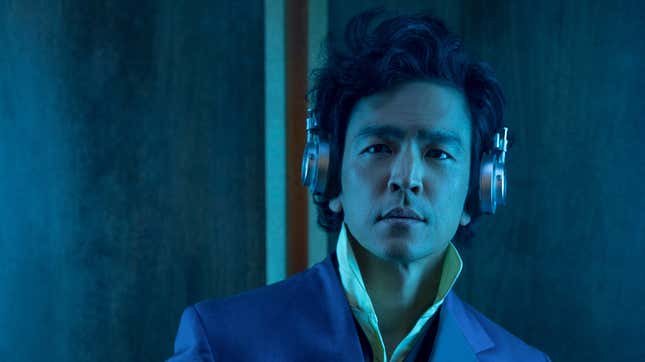 John Cho listens to some jams on headphones as Spike Spiegel in his classic suit in Netflix's live-action Cowboy Bebop.