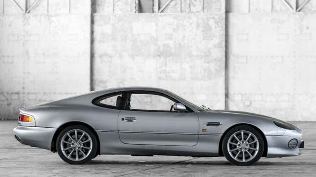 A side profile photo of a silver Aston Martin DB7 sports car. 