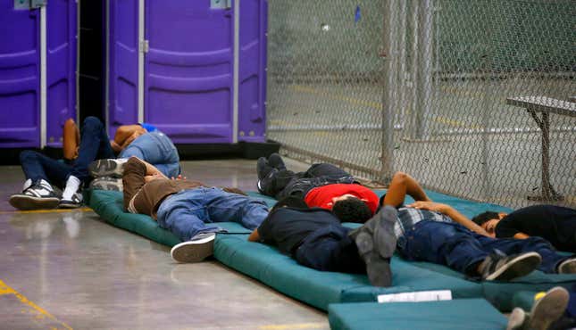 Young boys sleep in a holding cell.