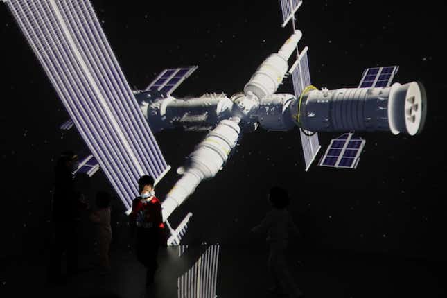 A child stands near a giant screen showing the images of the Tianhe space station at an exhibition featuring the development of China's space exploration on the country's Space Day at China Science and Technology Museum in Beijing, China April 24, 2021.