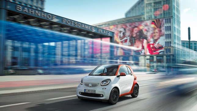 Ein weiß-orangefarbener Smart ForTwo Edition #1 beim Fahren in der Stadt