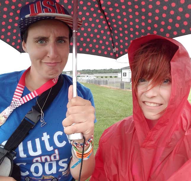 Un selfie yo con un poncho de lluvia y mi amigo sosteniendo un paraguas