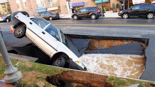 A  car sits in a sinkhole caused by a broken water main, which collapsed part of Friendship Blvd. on December 3, 2010 in Chevy Chase, Maryland. No one was reported injured in the accident