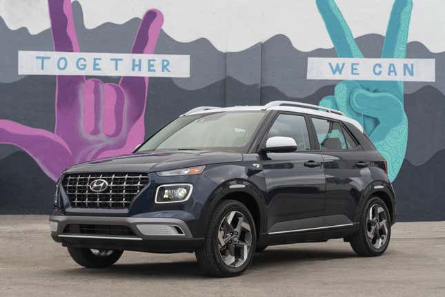 A 2020 Hyundai Venue Denim is parked in front of a mural, front-three-quarter view.