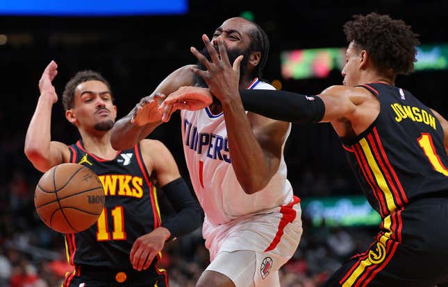 ATLANTA, GEORGIA - FEBRUARY 05: James Harden #1 of the LA Clippers draws a foul as he drives between Trae Young #11 and Jalen Johnson #1 of the Atlanta Hawks during the fourth quarter at State Farm Arena on February 05, 2024 in Atlanta, Georgia. NOTE TO USER: User expressly acknowledges and agrees that, by downloading and/or using this photograph, user is consenting to the terms and conditions of the Getty Images License Agreement. (Photo by Kevin C. Cox/Getty Images)
