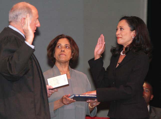 Kamala Harris reçoit le serment du juge en chef de la Cour suprême de Californie, Ronald M. George, lors de son investiture le 8 janvier 2004, en tant que procureur du district de San Francisco. Au centre se trouve la mère de Harris, Shyamala Gopalan.