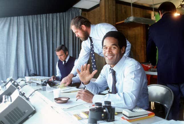 CIRCA 1980: NBC Football Analyst O.J. Simpson in the both smiling for the camera before the start of an NFL football game circa 1980.