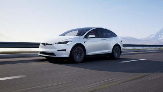 A white Tesla Model X Plaid driving along a mountain road