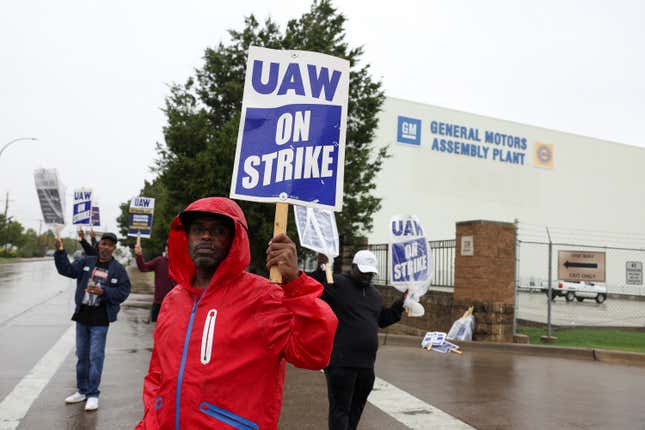 Workers holding placards striking at General Motors car plant