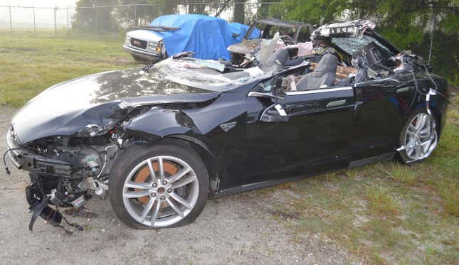 a photo of a decapitated Model S parked in a junkyard