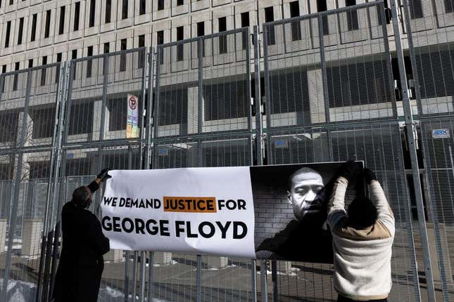 Jaylani Hussein (L), Executive Director of the Minnesota chapter of the Council on American-Islamic Relations (CAIR-MN) and a community activist, holds a banner during a press conference outside the US District Court in St. Paul, Minnesota, on January 20, 2022, for the jury selection of three former Minneapolis police officers charged with federal civil rights violations in George Floyd’s death. 