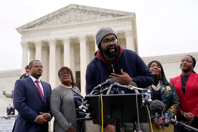 Evan Milligan, center, plaintiff in Merrill v. Milligan, an Alabama redistricting case, speaks with members of the press following oral arguments outside the Supreme Court on Capitol Hill in Washington, Oct. 4, 2022.