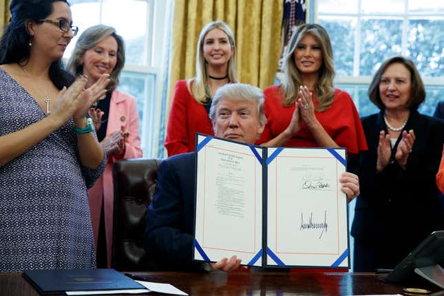 Trump shows one of two executive orders aimed at supporting women in STEM fields on Feb. 28, 2017, in the Oval Office.