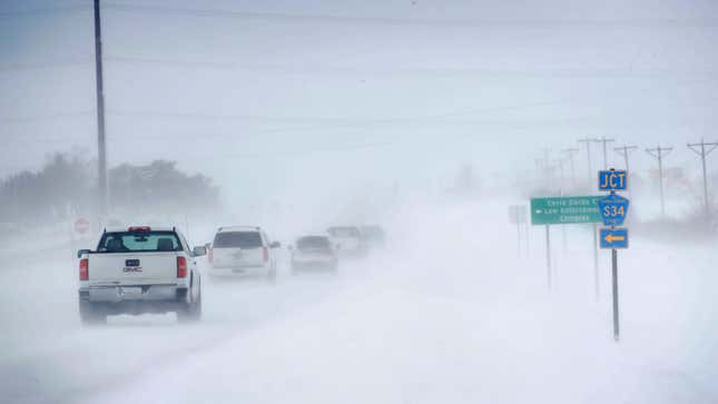 Ein Foto einer Reihe von Autos, die durch den Schnee fahren. 