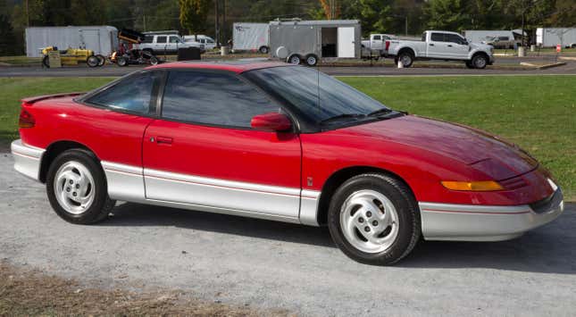 A 1992 Saturn SC2 leaving the show area at Hershey 2019. 25,000 miles, Bright Red with Black leather interior and an automatic. Near concours condition.