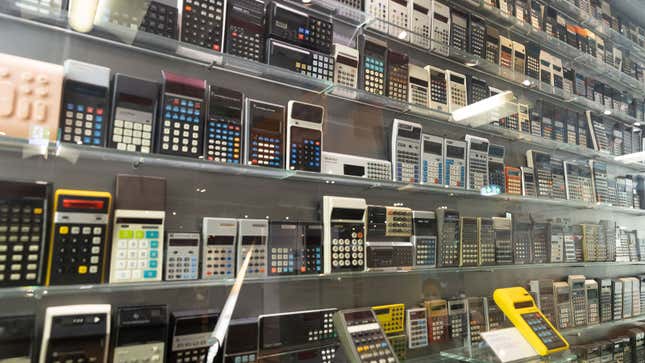 A photo of a wall covered in old calculators. 