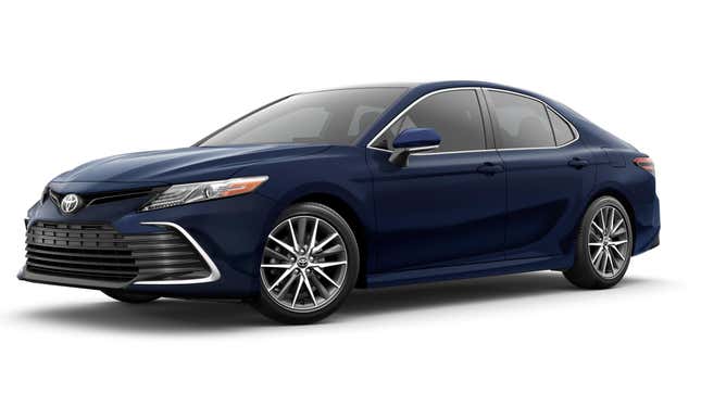 A dark blue Toyota Camry parked in front of a plain white background