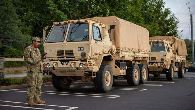 Two military trucks in a parking lot 